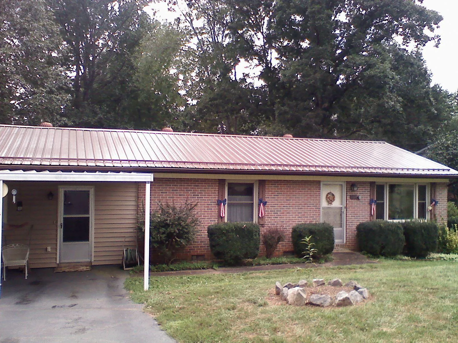 Bronze metal roof and carport on a brick ranch home — Roof Repair work by our crew in Watson